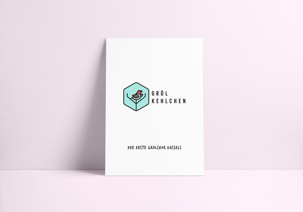Plakat vor einer rosa Wand: das Grölkehlchen-Emblem – ein grölender Vogel auf einer Gabelung, die Baum und Stimmgabel in einem ist, in einem türkisen Sechseck – daneben der Name in gesperrten Großbuchstaben.